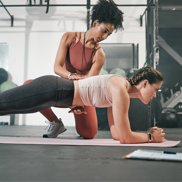 A Rev32 All-In Coach helping a member in a workout class